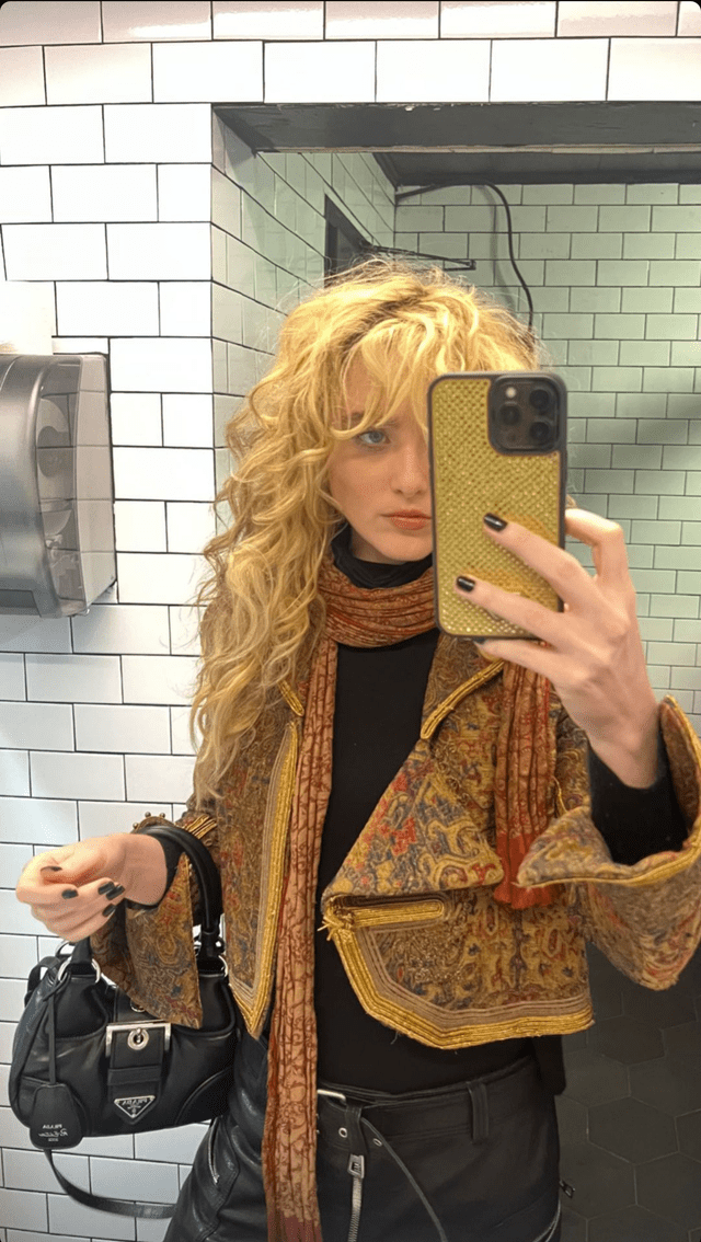 Kathryn mirror selfie wearing a yellow jacket (Via: Instagram Stories, March 15, 2023)